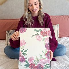 Teen holding white and pink floral box with blush background