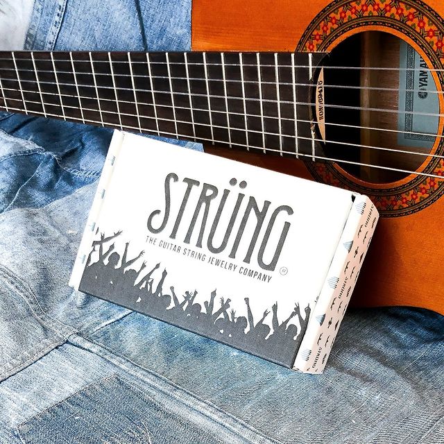 White mailer featuring guitar artwork and 'Str&uuml;ng' brand