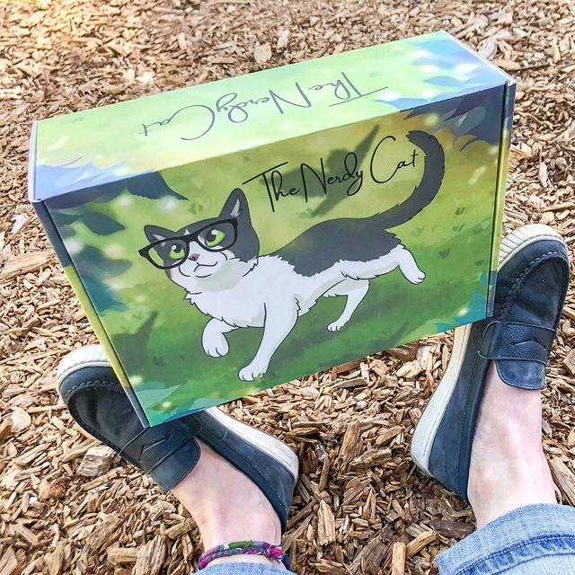 Colorful illustrated cat box with green forest scene