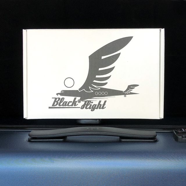 Laptop with white mailer featuring stylized falcon logo
