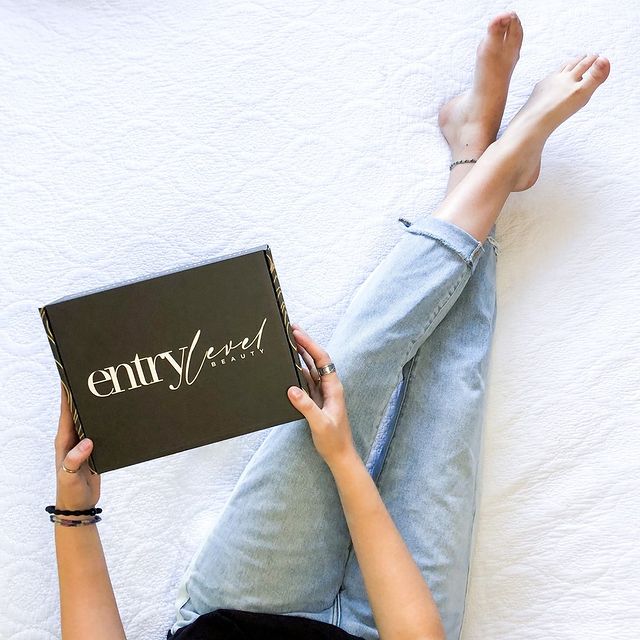 Person holding custom printed sample box from EntryVard while relaxing at home